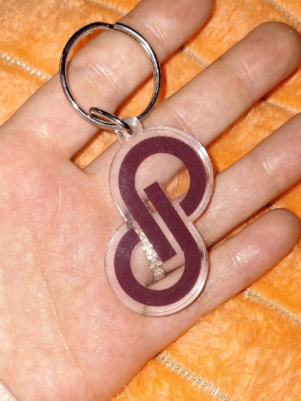 Clear acrylic keychain featuring a bold purple interlocking Poshmark logo.